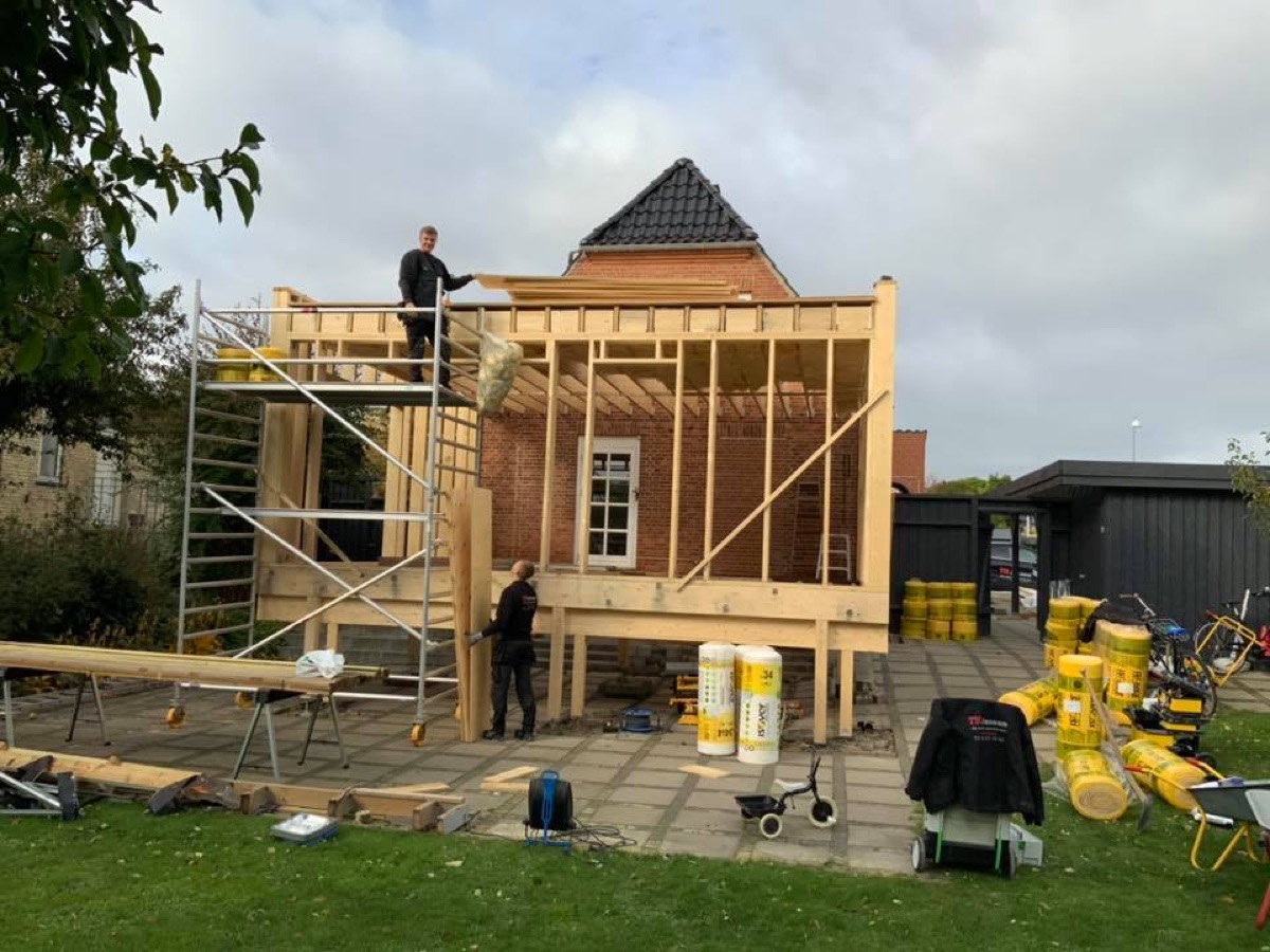 Tilbygning under opførelse med stillads omkring huset