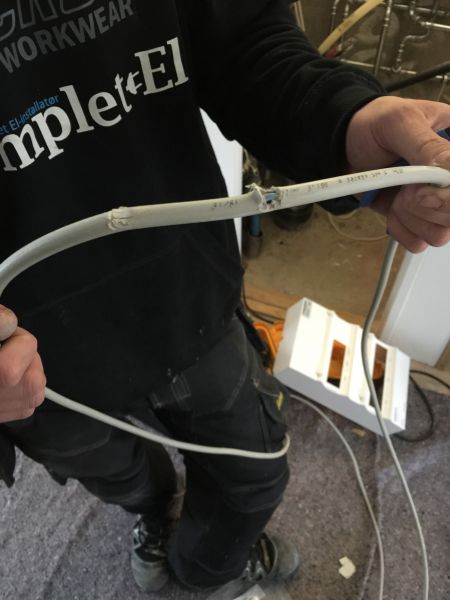 Elektriker fra Komplet-El i firmatøj under fejlsøgning på kabler